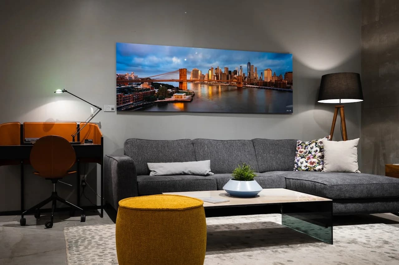 Mlad par koji vješa panoramsku fotografiju 15 × 30 cm iznad kauča