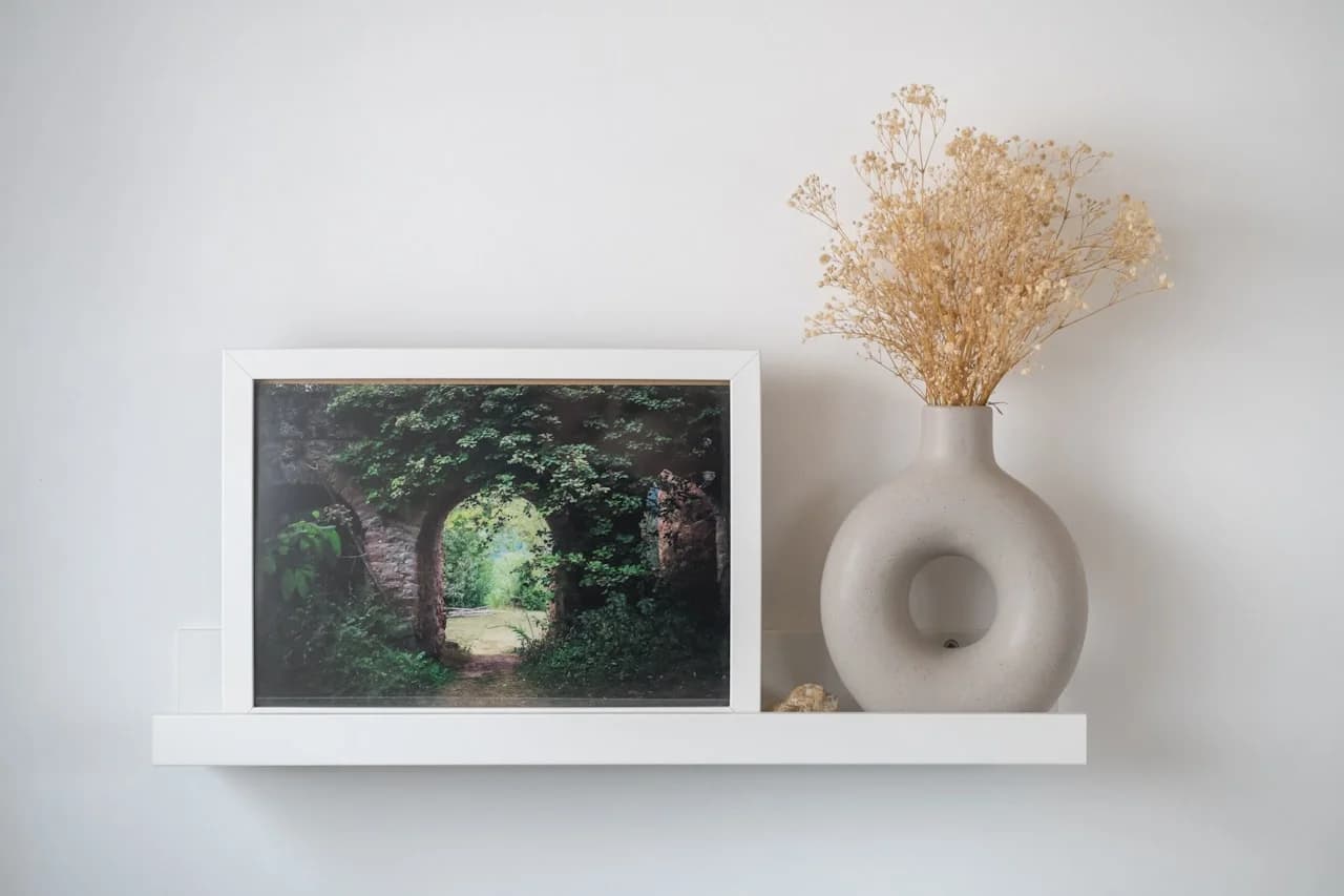 Više kvadratnih fotografija 15 × 15 cm na bijelom zidu u simetričnoj mreži