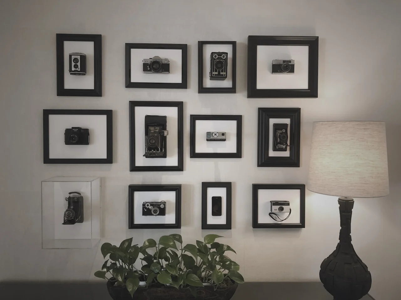 Galerijski zid s više uokvirenih fotografija u simetričnom rasporedu