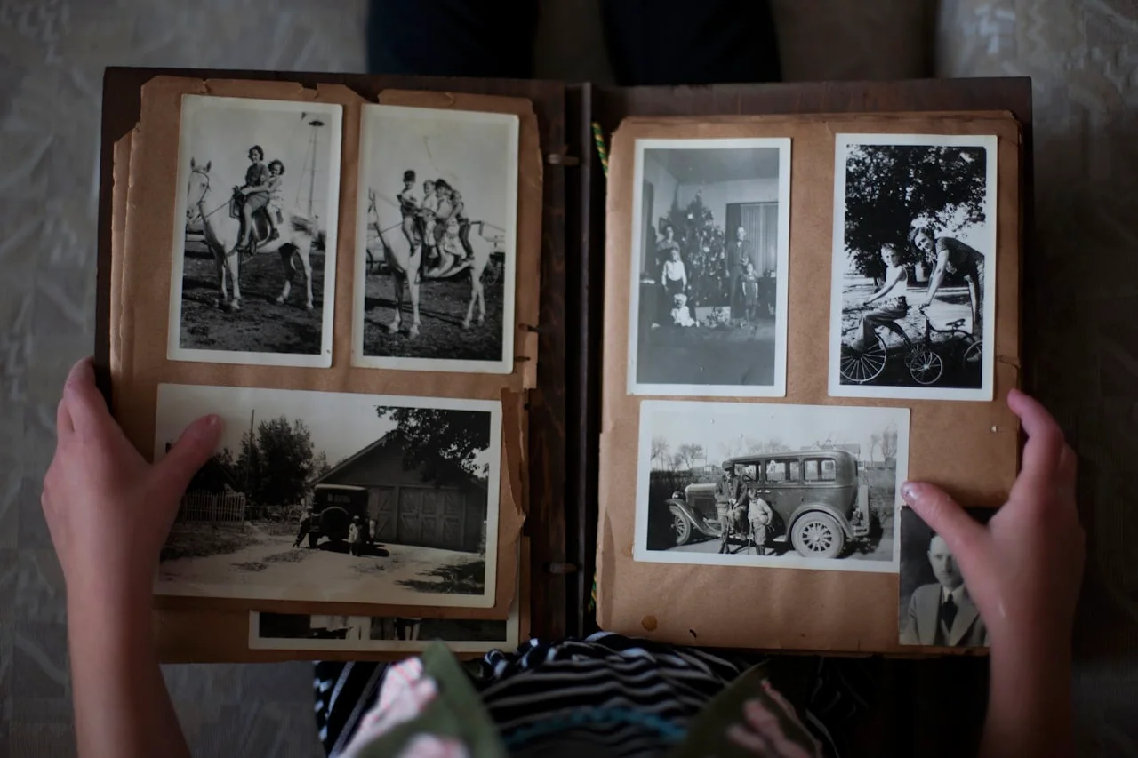 Ruke umeću male fotografije u klasičan fotoalbum