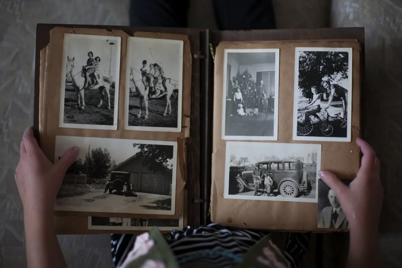 Album s fotografijama različitih veličina otvoren na stolu