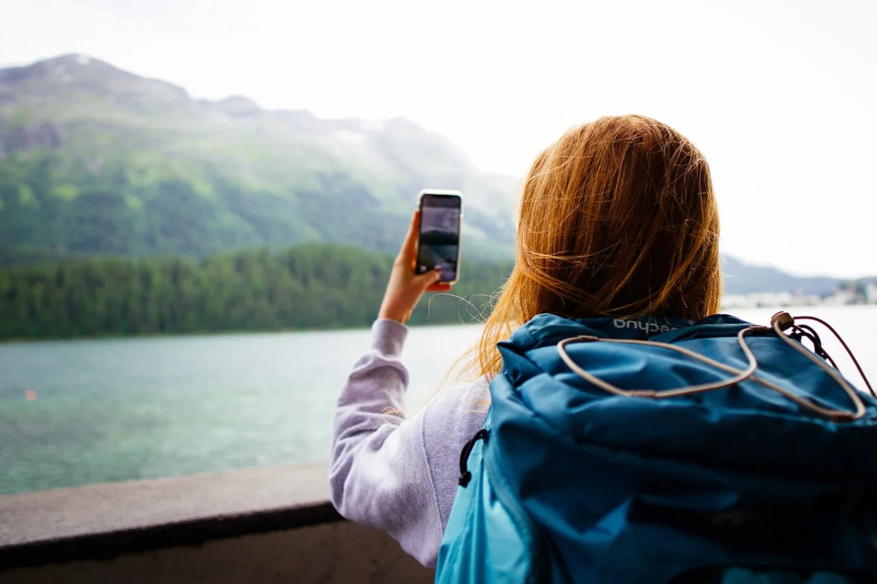 Putnica s ruksakom mobitelom fotografira planinsko jezero