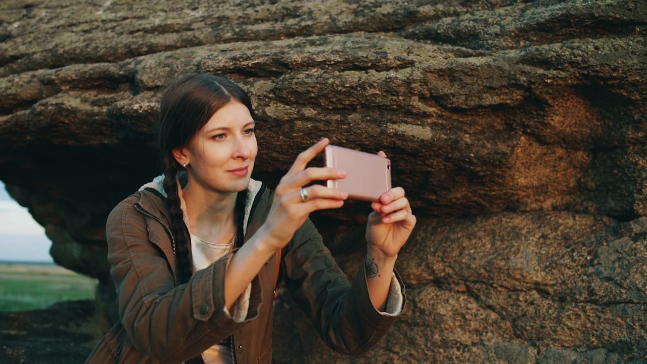 Žena mobitelom fotografira stjenoviti krajolik